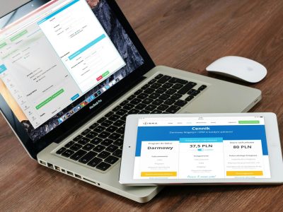 Close-up of a laptop and tablet on a wooden desk, showcasing modern technology.